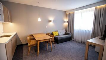 Una sala de estar moderna con un sofá, una mesa de comedor y un televisor.