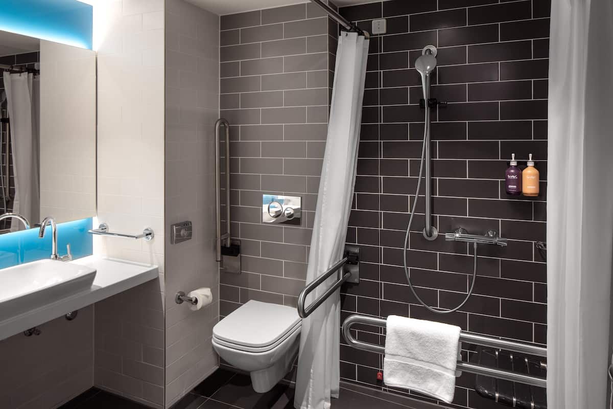 A modern bathroom with a white sink, toilet, and shower.