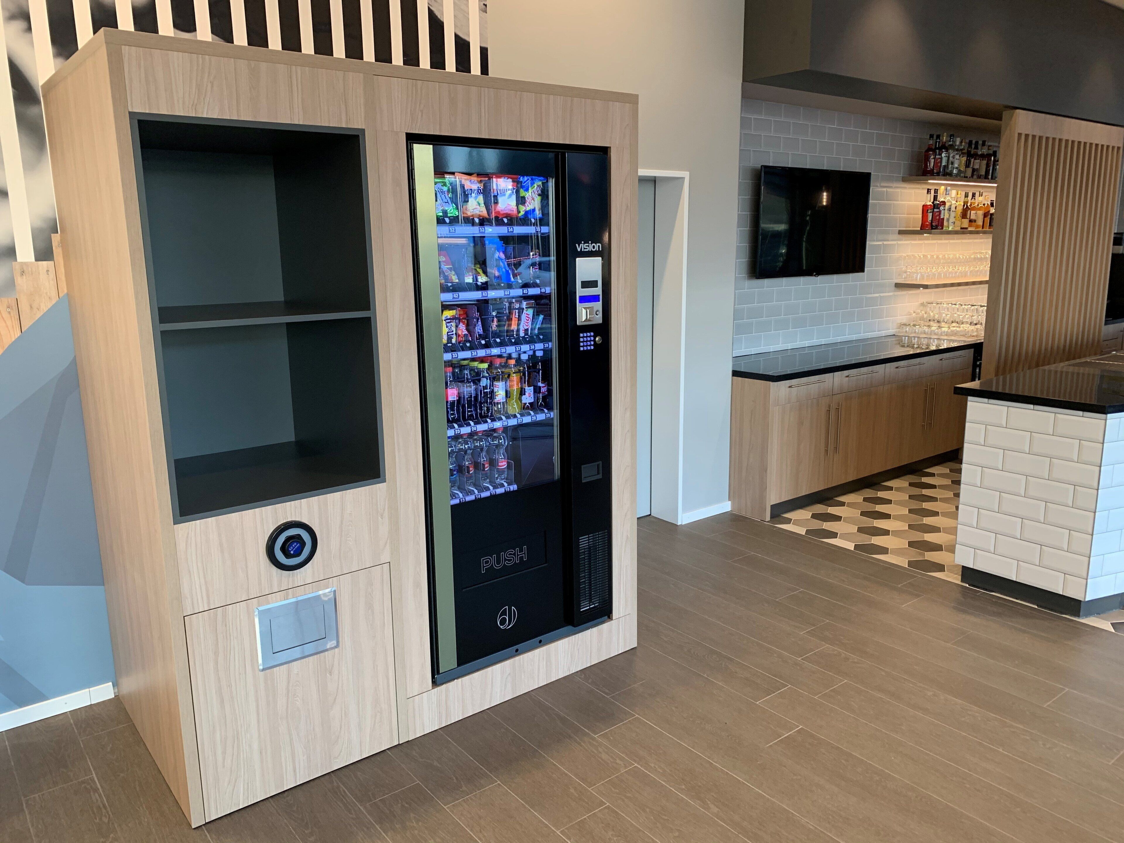 Una cocina moderna con una máquina expendedora empotrada, microondas y una zona de bar.