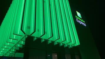 En bygning med grøn vertikal belysning og et skilt med Holiday Inn Express.