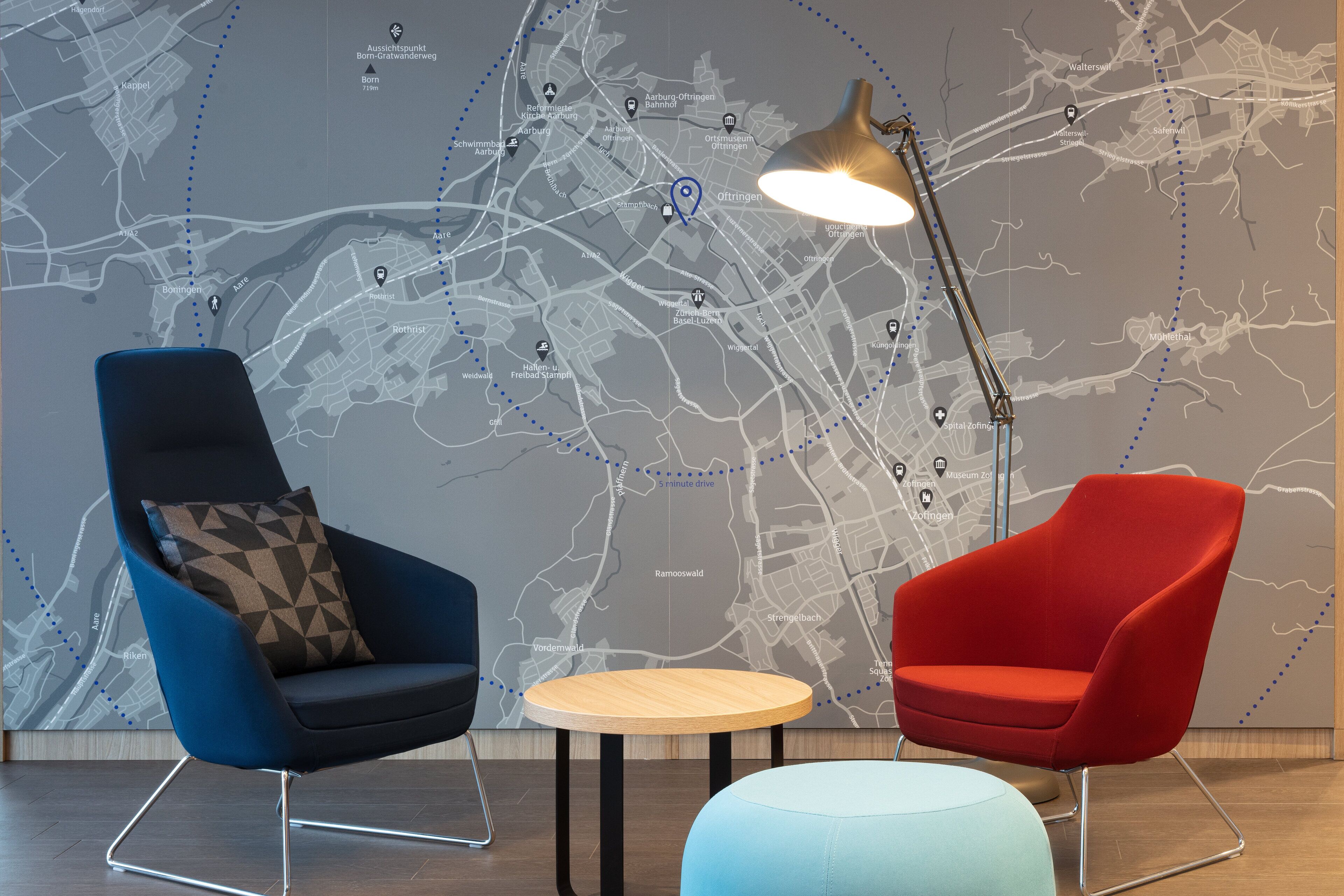 A modern interior with two chairs, a table, and a map on the wall.