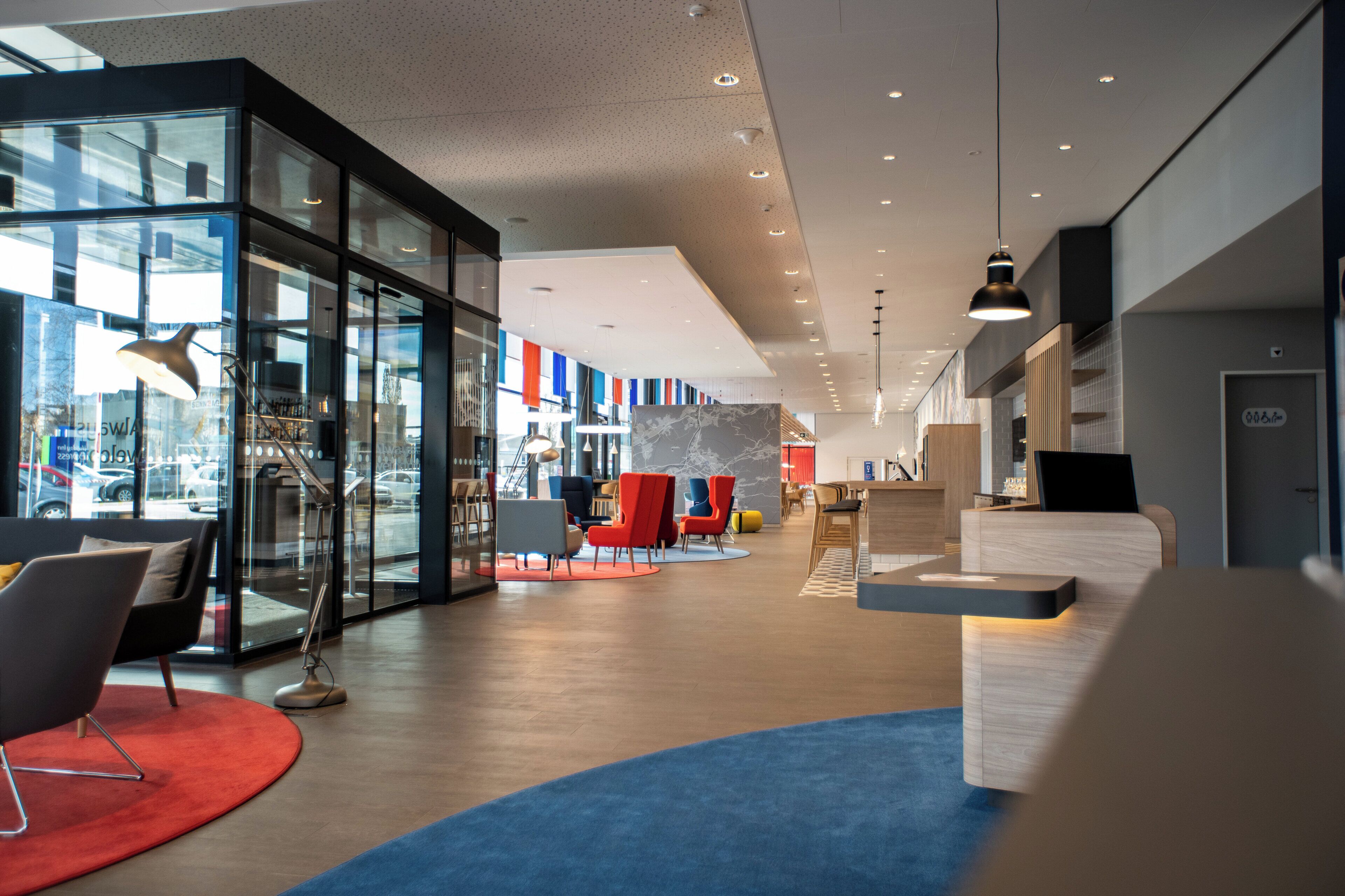 A modern interior with glass partitions, seating areas, and a reception desk.