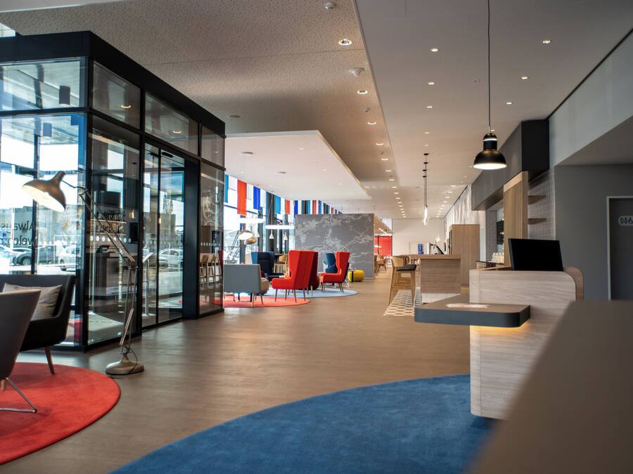 A modern interior with glass partitions, seating areas, and a reception desk.