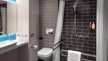 Ein modernes Badezimmer mit weißem Waschbecken, WC und Duschbereich.