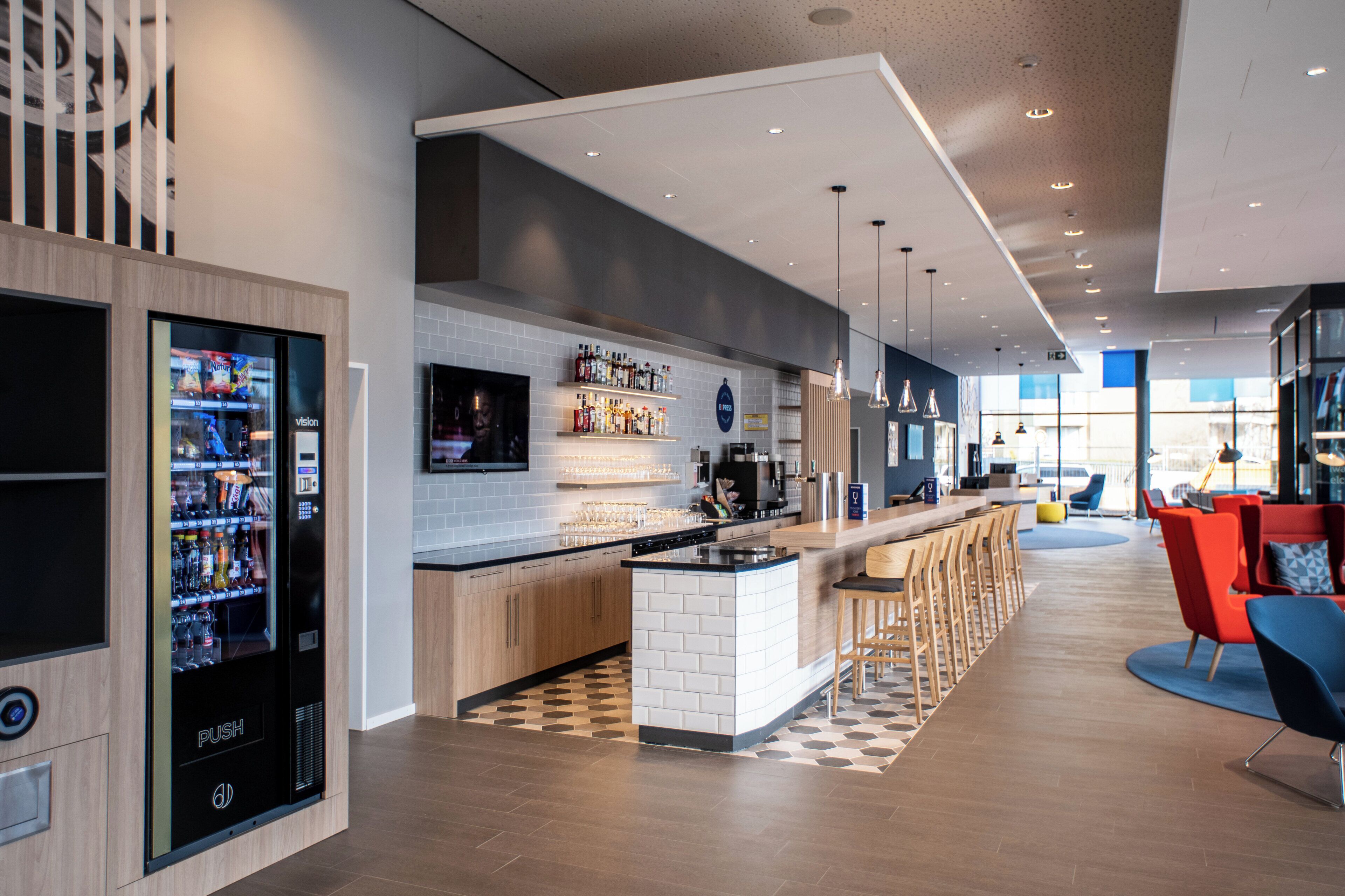 A modern kitchen with a central island, bar area, and seating.