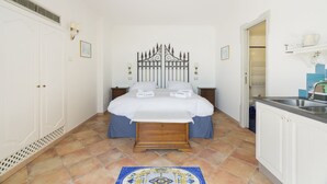 Een slaapkamer met een bed, nachtkastjes, een kledingkast en een zichtbare badkamer door een open deur.