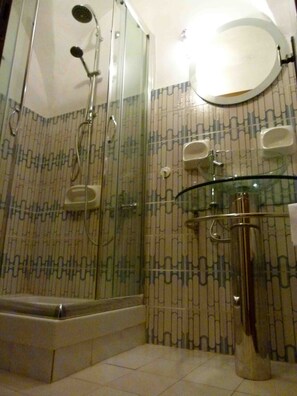 Een bad/douchecombinatie, een bidet, handdoeken, toiletpapier