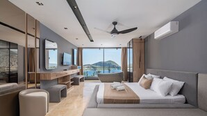 A modern hotel room with a large bed, a desk, a chair, and a view of the mountains. - Villa Buse, wonderful sea view. (Kalkan)