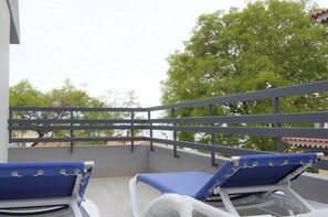 Ein Balkon mit zwei Liegestühlen und einer Brüstung.