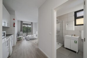 Een moderne keuken met witte kastjes en een ingebouwde magnetron.