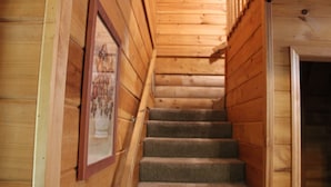 A wooden staircase with carpeted steps leading to an upper level. - Our open 2 -story, 2- Bedroom Cabin! (Hico)