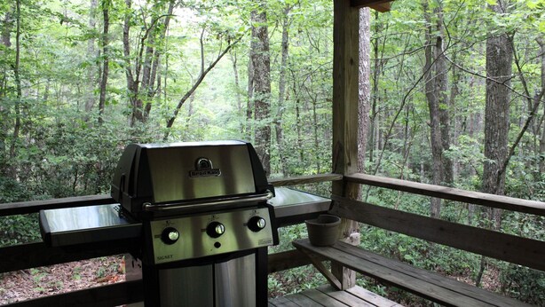 A grill on a wooden deck with a forest view. - Our open 2 -story, 2- Bedroom Cabin! (Hico)