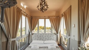 Une chambre à coucher avec un grand lit, des rideaux beiges et un lustre.