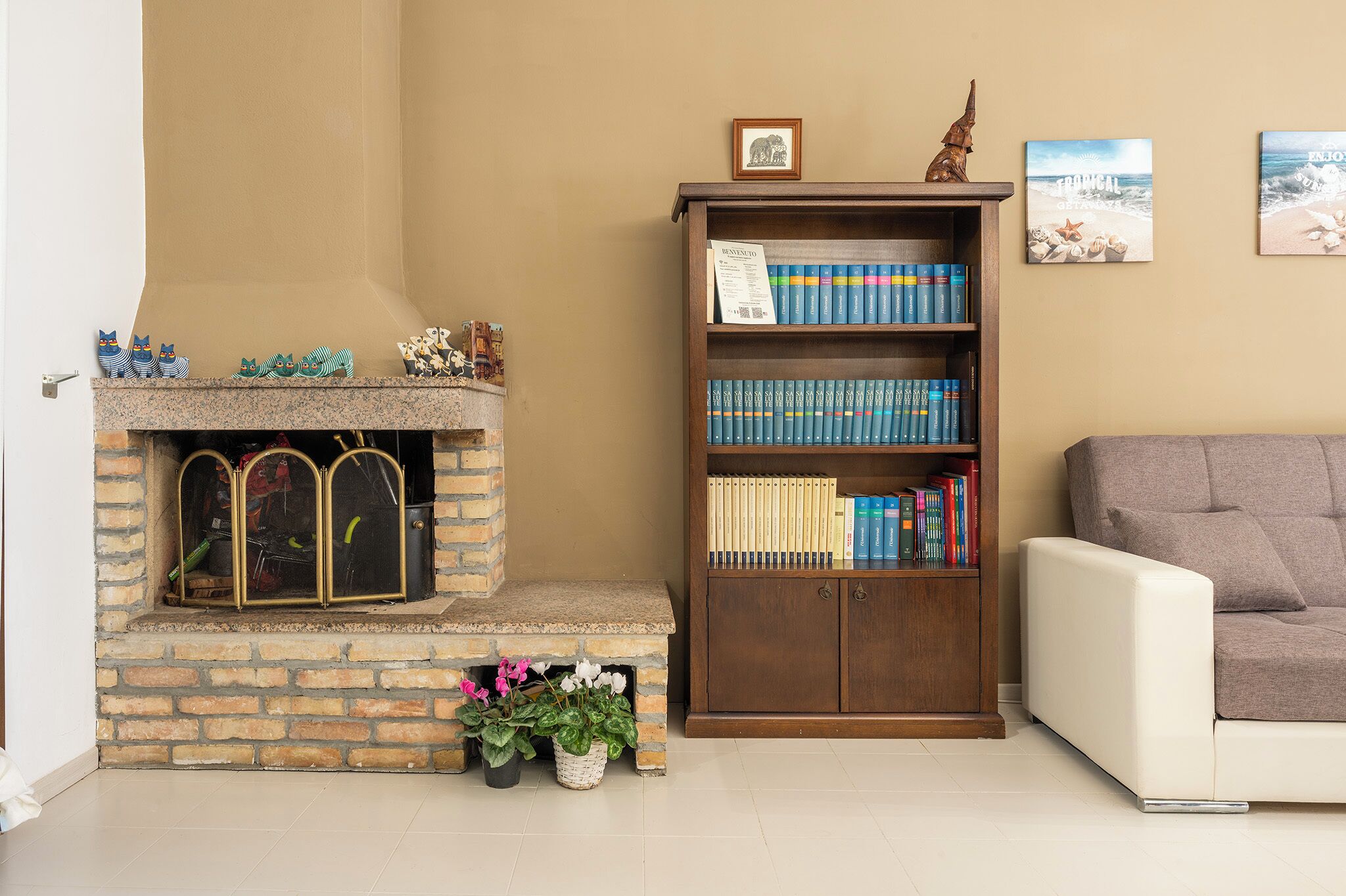 A living room with a fireplace, a bookshelf, and a couch.