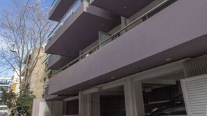 Ein mehrstöckiges Gebäude mit Balkonen, einer Garage und blauem Himmel.