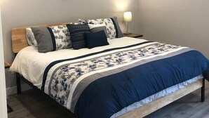 Una camera da letto con un letto, una ventola a soffitto e un comodino con una lampada.