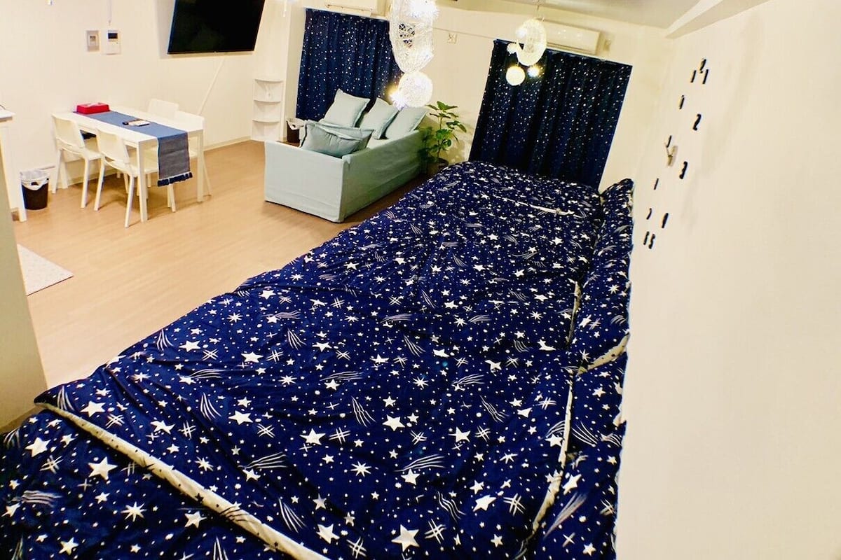 Un dormitorio con cama, escritorio, silla y sofá.