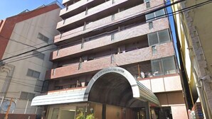 A multi-story building with a modern architectural design, featuring a prominent arched entrance and a visible balcony on the upper floors. - Mifune Central-Bear Shimanouchi No.2 Hotel (Osaka)