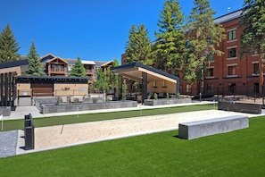 A hotel with a covered outdoor area, a sandpit, and a well-maintained lawn.