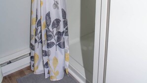 Ein Badezimmer mit einer Duschvorhangs, der ein Blattmuster zeigt.
