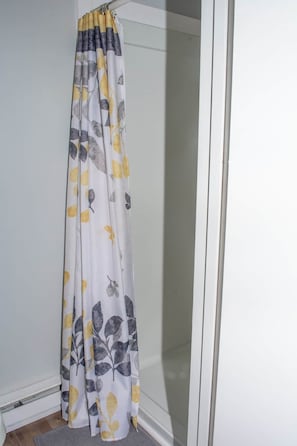 A bathroom with a shower curtain featuring a leaf pattern.