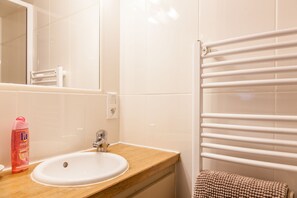 A bathroom with a white sink, a wooden countertop, a mirror, and a white towel rack. - The Wooden Man's Cottage - Atypical - historic center Honfeur (Honfleur)