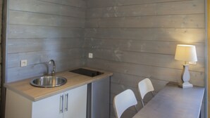 Una cocina compacta con lavamanos, armarios y un comedor con sillas y una mesa.