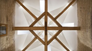 Una habitación con estructura de techo de madera y un tragaluz.