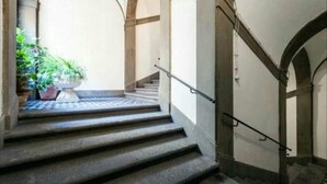 A staircase with a handrail, leading to an upper level. - Talents Home Historical center (Lucca)