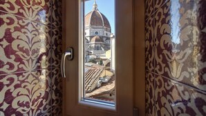 A door with a window view of a building with a dome and tiled roof. - Central apartment for visiting Florence (Firenze)
