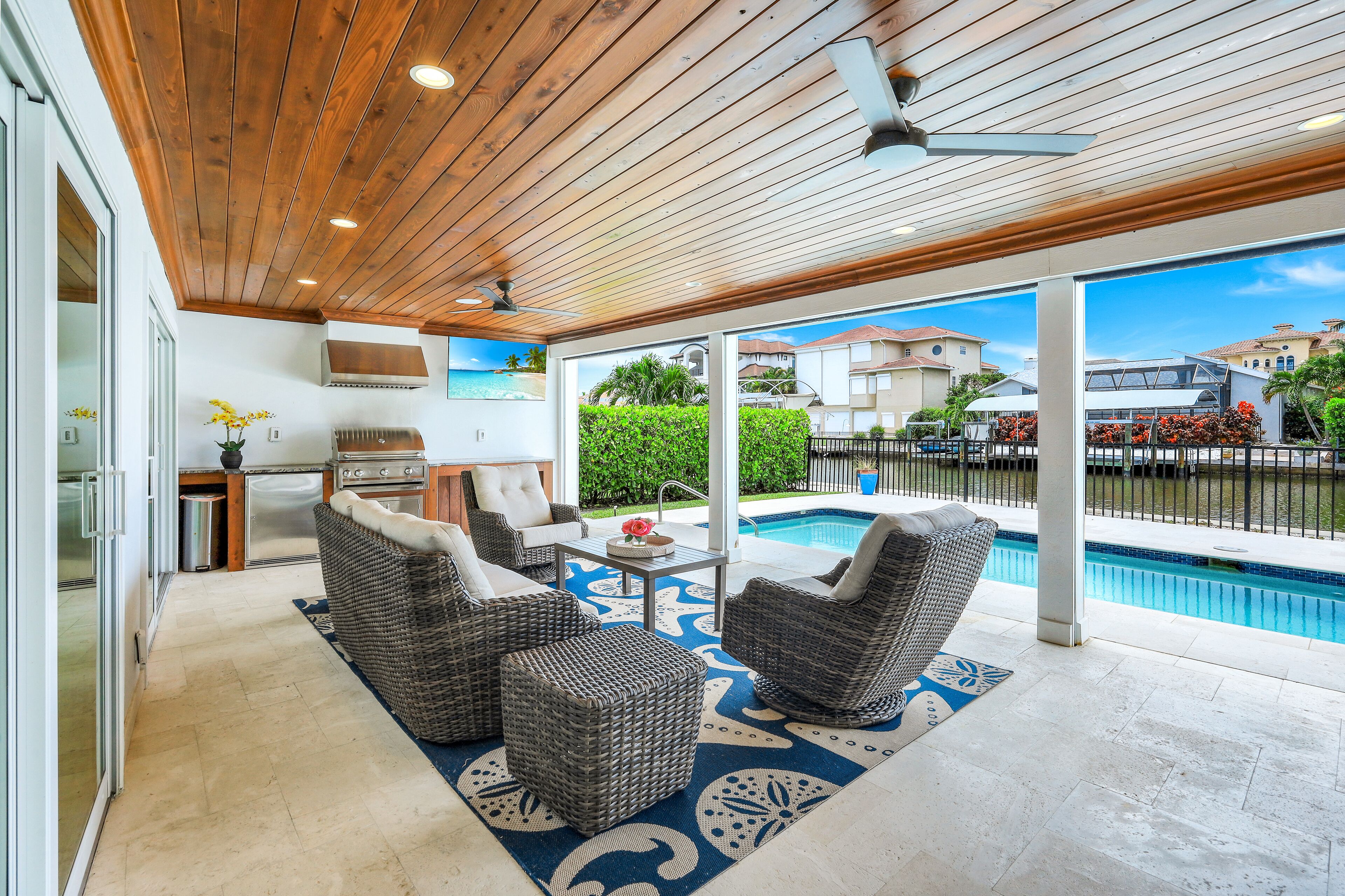 An outdoor patio with wicker furniture, a pool, and a view of the ocean.