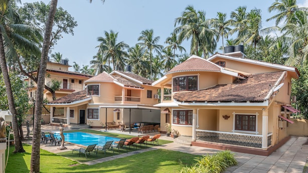 A resort with multiple two-story buildings, a swimming pool, and palm trees. - Villa Calangute Phase 4, Near Calangute Beach & Restaurants (Calangute)