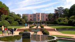 A courtyard with a fountain, steps leading to a building, and well-maintained greenery.