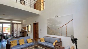 A spacious living area with a high ceiling, a large sofa set, a coffee table, and a fan. - Somone: large air-conditioned villa with swimming pool, 10 people *, between Sea and Lagoon (Unknown)