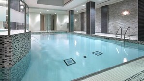 An indoor swimming pool with clear water, tiled walls, and a modern design. - 2-Bed, 2-Bath Condo w/Pool & Parking by Square 1 (Mississauga)