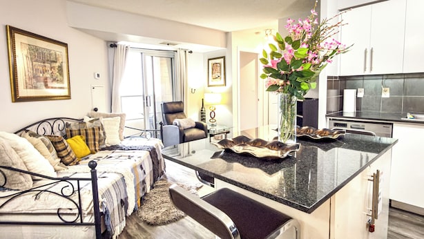 A modern hotel room with a bed, a sitting area, a kitchen, and a bathroom. - 2-Bed, 2-Bath Condo w/Pool & Parking by Square 1 (Mississauga)