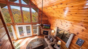 A cozy cabin interior with a wooden interior, a fireplace, a sofa, and a television. - Breathtaking Mtn VIEWS!! Cozy yet spacious peaceful cabin in the mountains! (Sevierville)