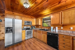 Enjoy cooking in this well-equipped kitchen with a refrigerator, microwave, oven, and dishwasher.