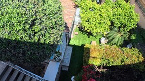 Un jardí a la teulada amb plantes diverses i una petita zona de seients.