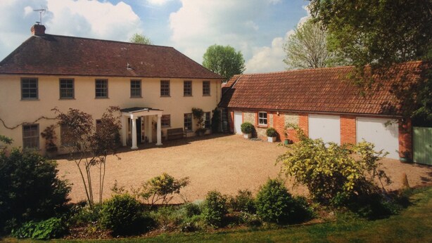 A two-story building with a covered patio and a fenced yard. - Chalkcroft lodge (Andover)