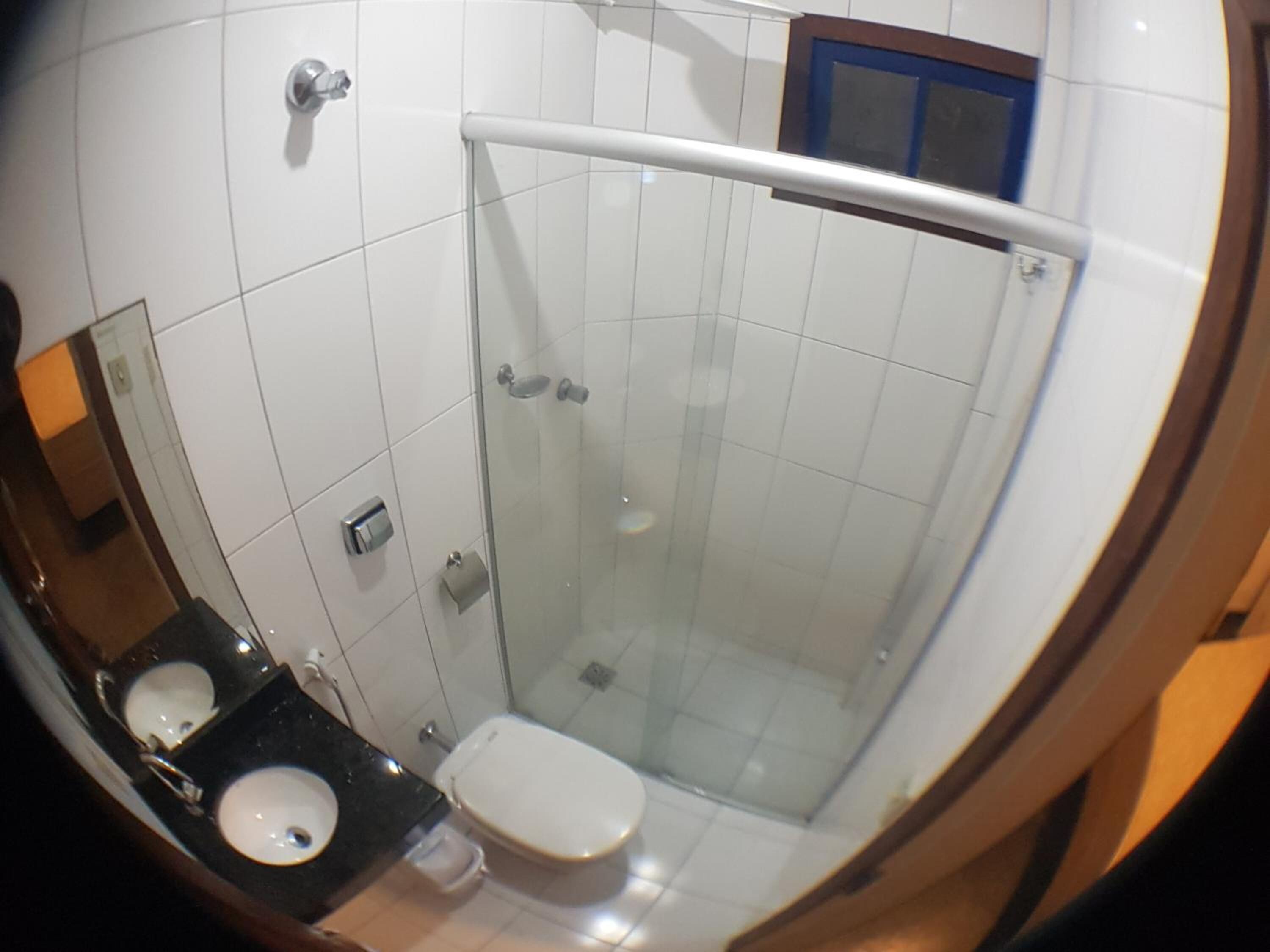 Un baño con dos lavamanos, un inodoro y una cabina de ducha con paredes de vidrio.