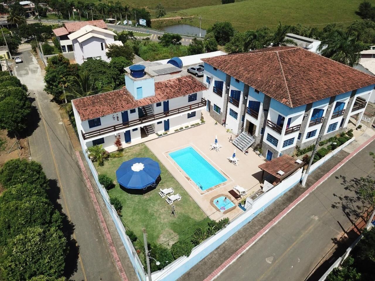 A two-story building with a swimming pool and a covered area.
