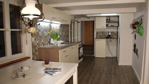 Una cocina moderna con encimera de madera, horno integrado y cafetera.