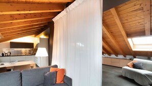 A modern loft with a kitchen, a dining area, and a living space with a sofa and curtains. - Sant Agostino Loft in historical city center (Catania)