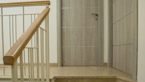 A set of marble stairs leading to a wooden door with a metal handrail. - Apartment Salgari Ponente (Marina di Ragusa)