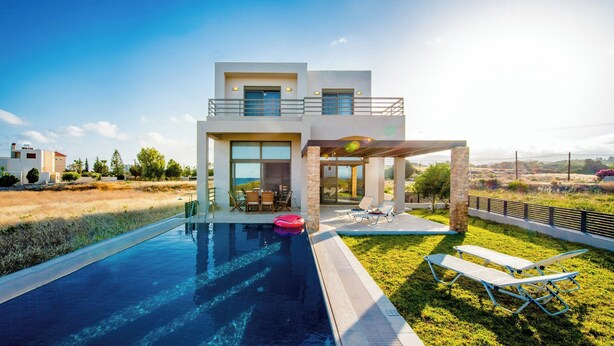 Ein modernes, zweistöckiges Haus mit Swimmingpool, Sitzgelegenheiten im Freien und Blick auf die Landschaft.
