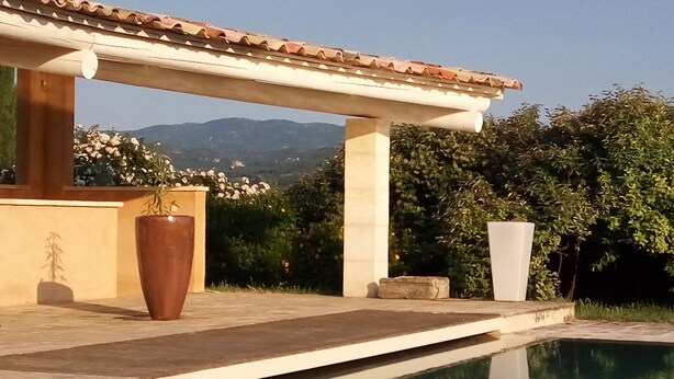 A poolside area with a pergola, a large planter, and a view of mountains. - Les Mûriers: 55m2 gite for 2/4 people in a quiet location overlooking the Luberon and vineyards (Gargas)