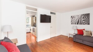 Un salon moderne avec un canapé, un téléviseur à écran plat et une œuvre d’art à motifs zébrés.