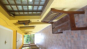 A staircase with a wooden handrail, a glass ceiling, and a view of greenery outside. - Recanto José Augusto (Mairiporã)