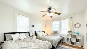 A bedroom with two beds, a ceiling fan, a radiator, and a bookshelf. - 6649 2W | Central St. Louis Beauty (St. Louis)